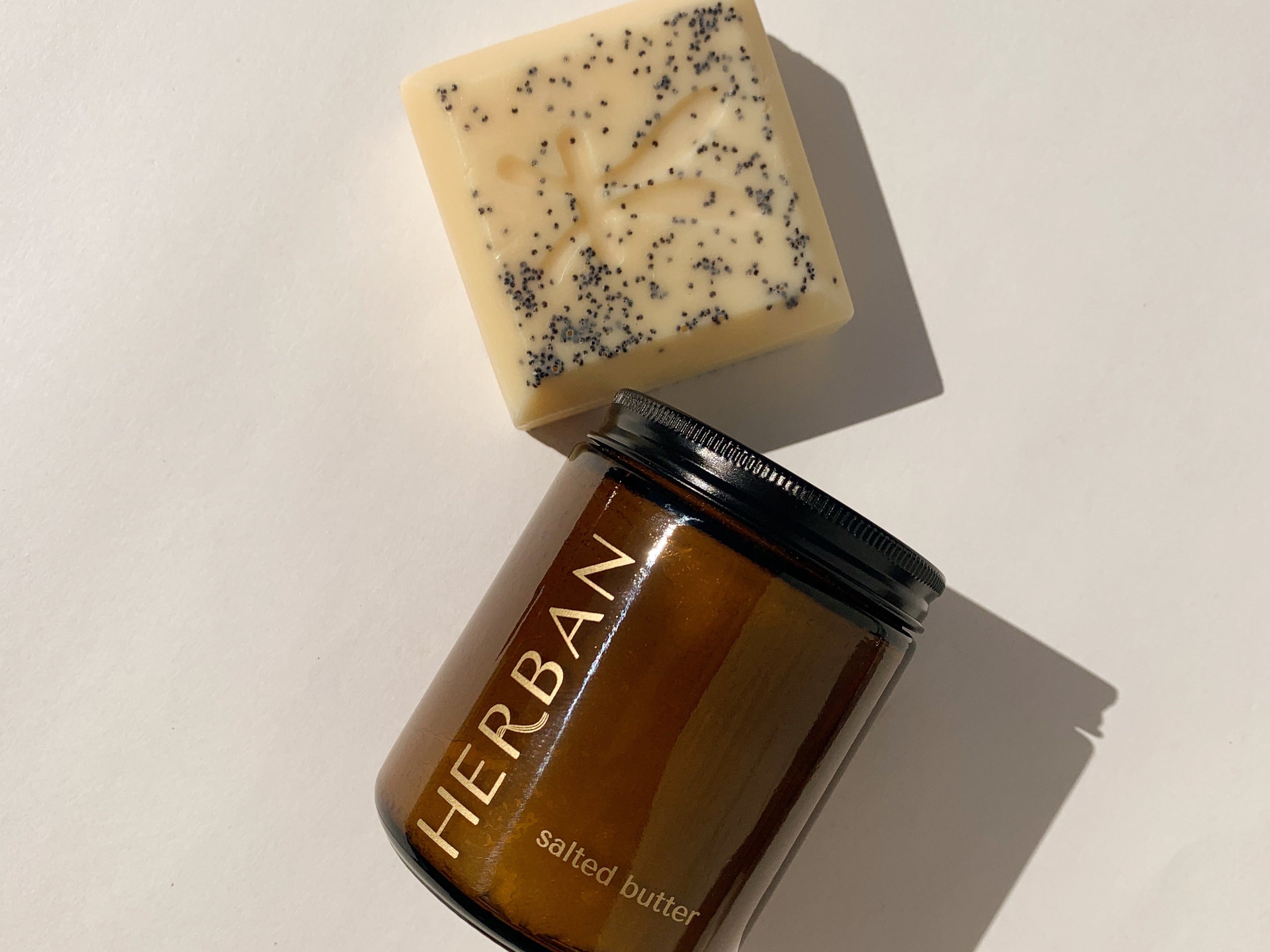 Herban Body Care Best Sellers include our signature humectant and herbal soap bar and our amber glass packaged, hydrating shea butter and sea salt body scrub!